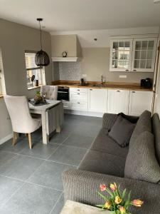 uma sala de estar com um sofá, uma mesa e uma cozinha em 't Huske em Werkendam