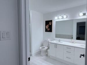 bagno bianco con lavandino e servizi igienici di Voltage a Ottawa