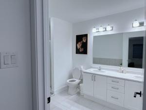 a white bathroom with a sink and a toilet at Voltage in Ottawa