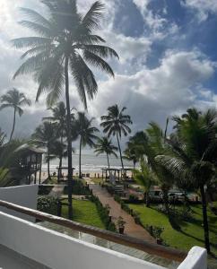 een balkon met uitzicht op het strand en de palmbomen bij MAYIM VILLA in Taipu