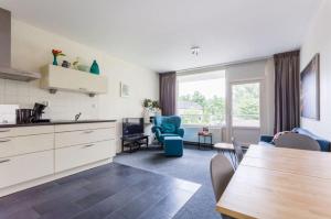 een keuken en een woonkamer met een tafel en stoelen bij Newa 1 in Amstelveen