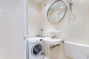 een badkamer met een wasmachine en een wastafel bij Newa 1 in Amstelveen