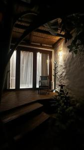 a dark room with a chair on a wooden deck at MAYIM VILLA in Taipu