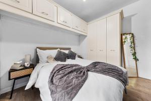 a white bedroom with a bed and a table at 1BDR Flat FREE Parking FREE Netflix & Wi-Fi in Goodmayes