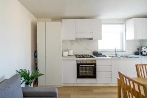 a kitchen with white cabinets and a stove top oven at +61 - Sea View Apartment in Agropoli