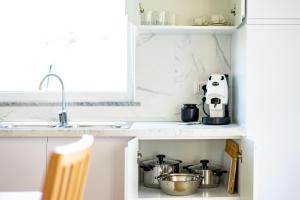 a kitchen with a counter with pots and pans at +61 - Sea View Apartment in Agropoli +21 photos