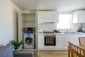 a kitchen with white cabinets and a washing machine at +61 - Sea View Apartment in Agropoli