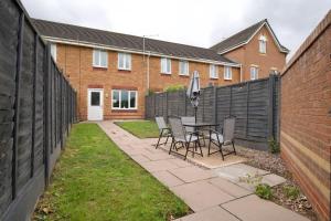 a patio with a table and chairs and a fence at 2Bed Haven - Coventry's Hidden Gem With Free Parking, Sky TV & Netflix in Coventry