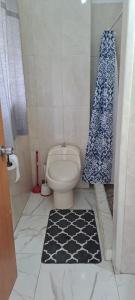 a bathroom with a toilet and a shower curtain at Carib condo in Ocho Rios