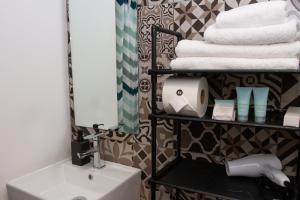 a bathroom with a sink and a shelf with towels at NIU Reforma in Mexico City +52 photos
