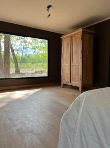 a bedroom with a large window and a bed at Estancia San Alberto Lodge in Uspallata