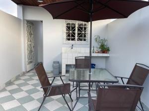 d'une terrasse avec une table, des chaises et un parasol. dans l'établissement Casita en el centro de la ciudad, à Iquitos
