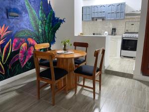 une cuisine avec une table et des chaises en bois ainsi qu'un tableau dans l'établissement Casita en el centro de la ciudad, à Iquitos