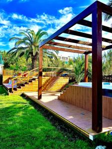 a wooden pavilion with stairs and a palm tree at Casa Caloura Seaside Deluxe Accommodation & Spa in Lagoa
