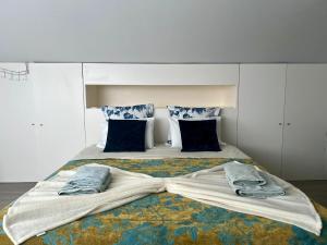 拉戈阿Casa Caloura Seaside Deluxe Accommodation & Spa的一张大床,上面有两双鞋