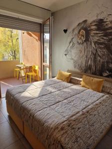 a bedroom with a large bed with a lion painting on the wall at Nyx Lilura Foresteria Lombarda in Seriate