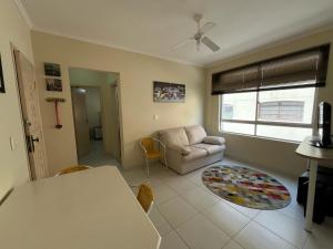 a living room with a couch and a table at Apartamento na Praia in Guarujá