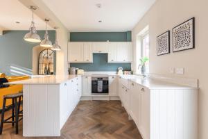 a kitchen with white cabinets and a large island at Ness at the Park in Inverness