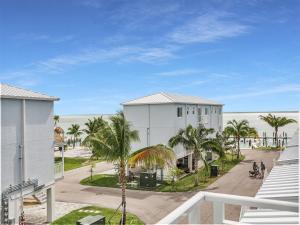 un edificio blanco con palmeras frente a la playa en Atlantic Breeze NEW 1Bed 2Bath Condo, en Marathon