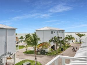 a white building with palm trees in front of the beach at Atlantic Breeze NEW 1Bed 2Bath Condo in Marathon