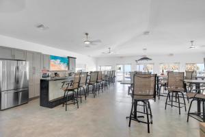 a large kitchen with chairs and a bar with a counter at Atlantic Breeze NEW 1Bed 2Bath Condo in Marathon