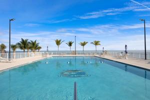 a large swimming pool with the ocean in the background at Atlantic Breeze NEW 1Bed 2Bath Condo in Marathon