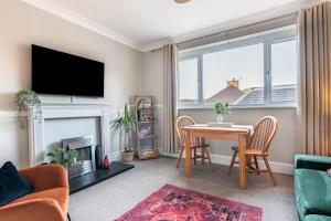 a living room with a table and a fireplace at Sweet Ness River Flat, Inverness City in Inverness