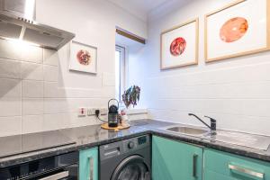 a kitchen with a washing machine and a sink at Sweet Ness River Flat, Inverness City in Inverness