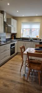 a kitchen with white cabinets and a table and chairs at Manby Fields, Manby in Louth