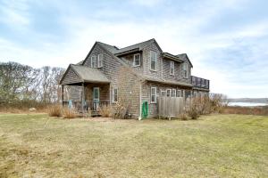 an old brick house in a grassy field at Beautiful Aquinnah Home Ocean View, Walk to Beach in Lobsterville