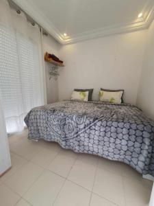 a bedroom with a bed with a blue and white comforter at YoYo House in Sidi Bou Saïd