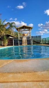 uma piscina com um gazebo no meio em Rancho Encanto de Furnas - Guapé em Guapé