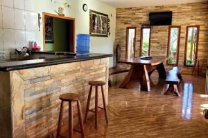 a kitchen with a bar with stools and a table at Rancho Encanto de Furnas - Guapé in Guapé