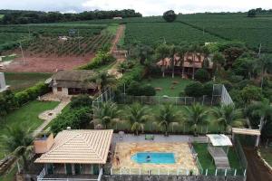 瓜佩的住宿－Rancho Encanto de Furnas - Guapé，享有带游泳池的房屋的空中景致