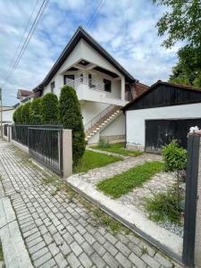 a white house with a fence in front of it at Cozy Skopje House in Skopje
