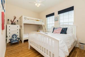 a white bedroom with a bunk bed and a crib at Amazing 360 Ocean & Bay Water Views in Freeport