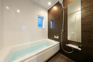 bagno con ampia vasca e doccia di 【KUON クオンSea & BBQ】愛犬同伴OK BBQが出来る一棟貸切宿 a Kujukuri