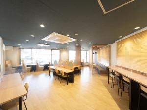 una sala de conferencias con mesas, sillas y ventanas en Sun Hotel Kokubu Kagoshima en Kirishima