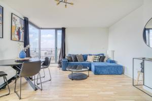 a living room with a blue couch and a table at Grand appartement avec belle vue Paris in Rueil-Malmaison +19 photos