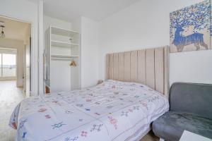 een slaapkamer met een bed en een stoel bij Grand appartement avec belle vue Paris in Rueil-Malmaison