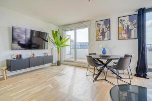 een eetkamer met een tafel en stoelen bij Grand appartement avec belle vue Paris in Rueil-Malmaison