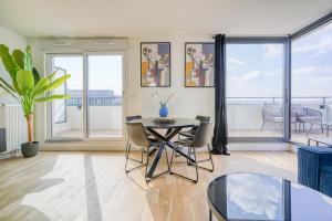 a living room with a table and chairs and windows at Grand appartement avec belle vue Paris in Rueil-Malmaison