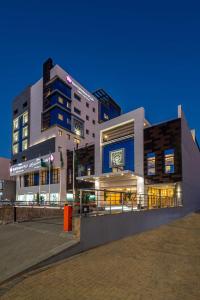 un grand bâtiment avec des lumières allumées devant lui dans l'établissement Best Western Plus Tabuk City Center, à Tabuk