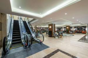 an empty lobby with an escalator in a mall at Best Western Plus Tabuk City Center in Tabuk