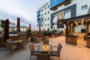 een patio met tafels en stoelen en een gebouw bij Best Western Plus Tabuk City Center in Tabuk