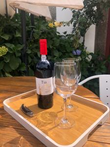 een fles wijn en een glas op een dienblad bij Quinta Da Estrada Winery Douro Valley in Peso da Régua