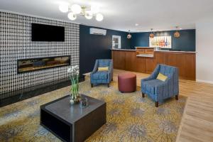 Best Western - Freeport Inn في فريبورت: غرفة انتظار مع كرسيين ومدفأة