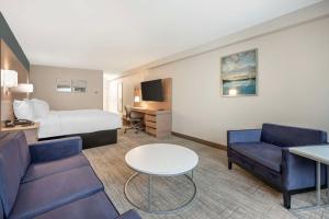 アシュランドにあるBest Western River Citiesのベッド、ソファ、テーブルが備わるホテルルームです。