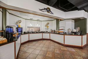 a large kitchen with a counter in a restaurant at Best Western Orlando Gateway Hotel in Orlando +42 photos