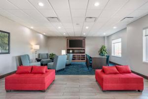 a waiting room with two red chairs and a table at Best Western Plus Owensboro in Owensboro